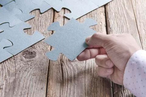 Incomplete puzzles lying on wooden rustic boards. Stock Photos