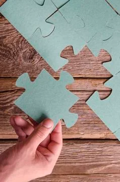 Incomplete puzzles lying on wooden rustic boards. Stock Photos