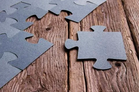 Incomplete puzzles lying on wooden rustic boards. Stock Photos
