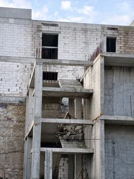An incomplete structure with concrete walls and protruding metal rebar, a s.. 写真素材