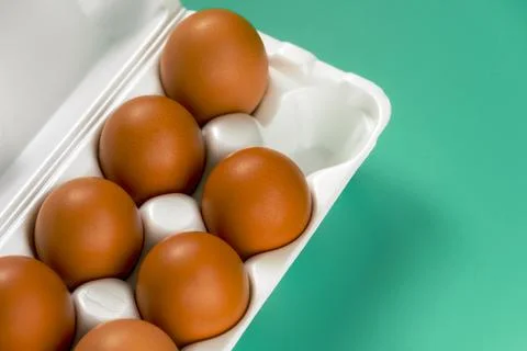 Incomplete white container box of farm fresh brown chicken eggs. Stock Photos