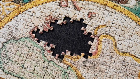 Incomplete world map puzzle lying over dark background forming structure closeup Stock Footage 332310066