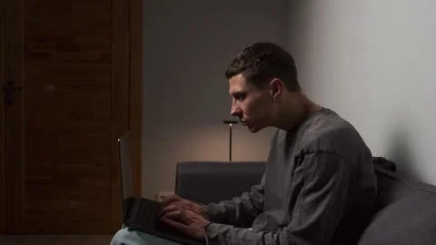 Incorrect posture while working on laptop. Young man sitting hunched on sofa 스톡 동영상 315414335