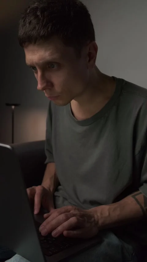 Incorrect posture while working on laptop. Young man sitting hunched on sofa Stock Footage 316145719