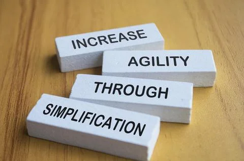 Increase agility through simplification text on white wooden blocks Foto stock