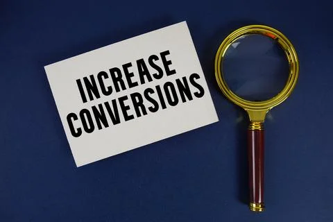 Increase Conversions text written on paper with magnifying glass Stock Photos