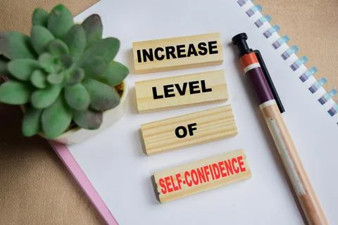Increase level of self-confidence on stacked wooden cubes on the table. 库存照片
