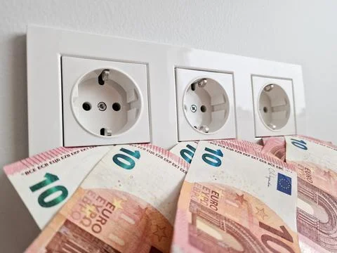 Increased electricity cost concept with money and AC socket Stock Photos