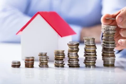 Increased Stack Of Coins In Front Of House Model 스톡 사진