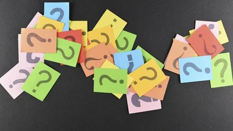 Increasing pile of colorful QUESTION MARK on black paper background Stock Footage 93344271