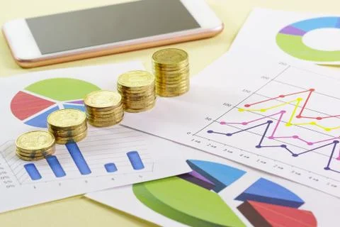 Increasing in the size of the stack of gold coins are on colored charts. Visu Stock Photos