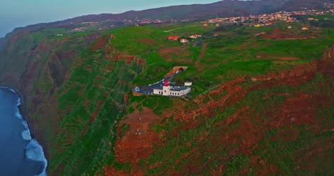 An incredible aerial view of a lighthouse on a high cliff at twilight, on the Stock Footage 345445587