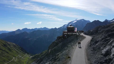 Incredible building at the top of the world, a couple, mountains, twisty road Stock Footage