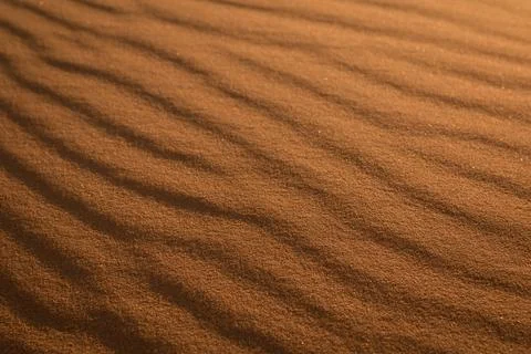 Incredible wavy diagonal patterned textured sand waves on a desert or beach.. Stock Photos