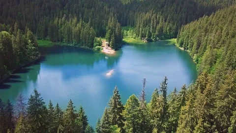 Incredibly beautiful blue lake surrounded by green pines and firs in the Stock Footage 80400751