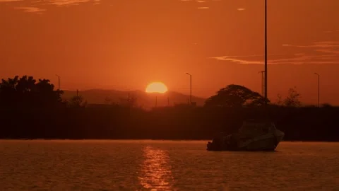 Incredibly beautiful view of red disk of sun setting behind top of mountain and Vidéo 314235121