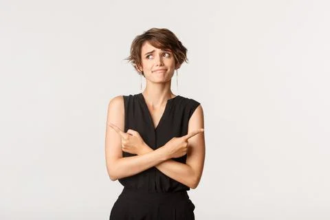 Indecisive cute girl having problem with making choice, pouting perplexed Stock Photos