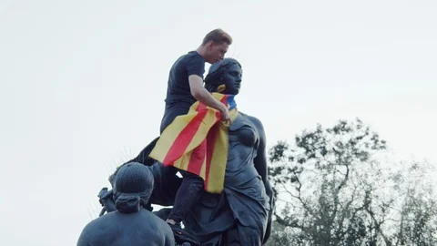 Independence protestor drapes Catalan flag Senyera on a statue in Barcelona Vídeo Stock 118550094