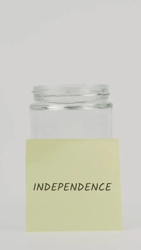Independence text or word on yellow sticky note attached to glass jar Stock Footage 311743145