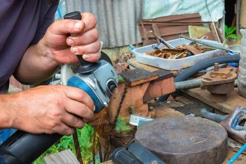 Independent tool making using a vise and angle grinder, hands of a wizard, wo Stock Photos