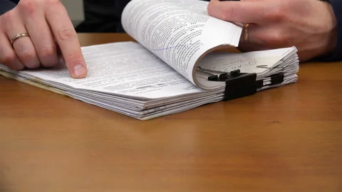 The index finger moves through the text in the document Stock Footage 99935112