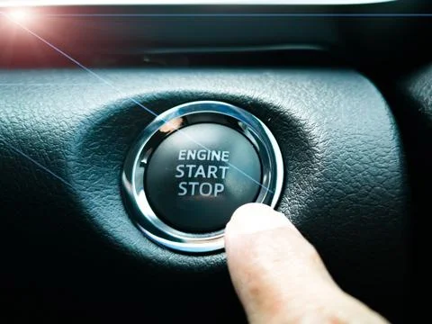 The index finger is pressing the engine start stop botton Fotos de archivo