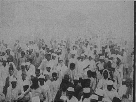 INDIA 1930: A pilgrimage of Indian men. Drummers and flutists wearing mundus, Stock Footage
