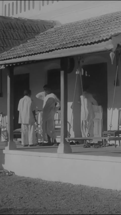 INDIA - 1942 - Officials wait outside Gandhi's home for him. Stock Footage 342628493