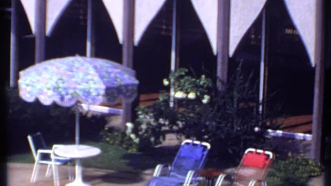 INDIA-1969: Pool Chairs Table Umbrella And Pool With Man Swimming Backwards Vidéo 125062804
