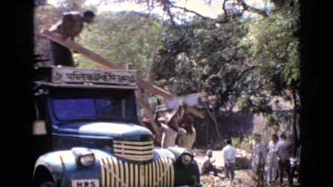 INDIA-1970: People Loading Lumber Into Green Truck On A Bright Sunny Day Video stock 125010091