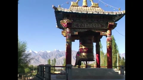 INDIA - 1999 - Distant view of a Buddhist using a prayer wheel in India. Stock Footage 341673241