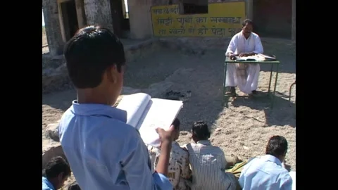 INDIA - 1999 - View from behind a boy as he reads his report to his teacher 스톡 동영상 327373308