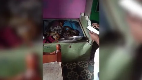 India: 8-foot python discovered in bed storage box in central India, safely... Stock Footage 282445858