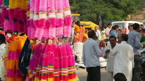 India bazaar, people chat behind vendors selling colorful decoration Stock Footage