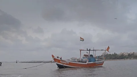 India, boat is docked in the sea while a passenger airplane flying in sky Stock Footage 107962236