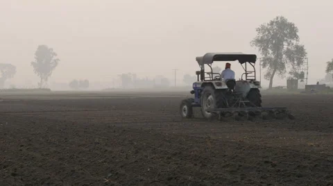India, a farmer plows his land on a tractor Stock Footage
