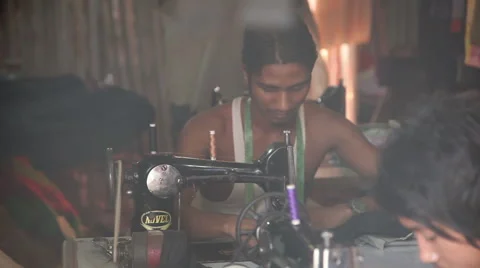 INDIA, GOA - 2012: The Indian men sew clothes for sale Stock Footage 45591661