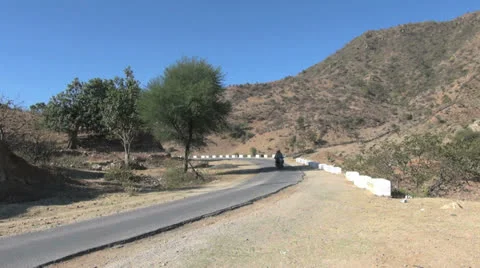 India Rajasthan Deogarh motorcycle dodges big truck Stock Footage 24453070