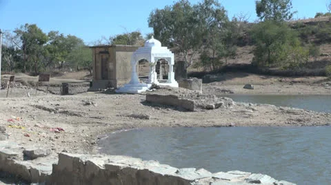 India Rajasthan Deogarh small temple by pond off road  Stock Footage 24425802