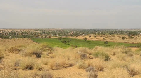 India Rajasthan Manvar green plot with barren surroundings  Stock Footage 24590067