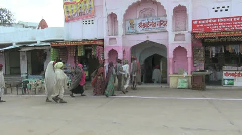 India Rajasthan Pushkar pilgrims enter temple past pink arches 2 Stock Footage 24631178