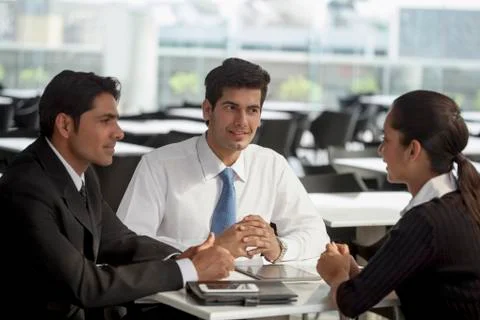 India, Three colleagues discussing at table Stock Photos