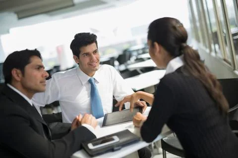 India, Three colleagues working in cafeteria Stock Photos
