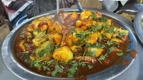 Indian Aloo curry - Potato immersed in an Onion Tomato Gravy and garnished Stock Footage 238755366
