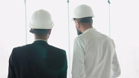 Indian and arabian builders engineers workers in helmets walking on construction Stock Footage 236477143