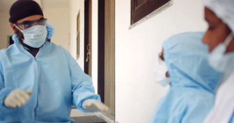 Indian and nurses in full body ppe suit share talk discuss teamwork together Stock Footage 146330403