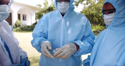 Indian and nurses in full body ppe suit share talk discuss teamwork together Stock Footage 146330701