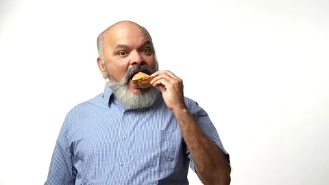 Indian Asian elderly gentleman with a beard  enjoys a samosa secretely Stock Footage 343360322
