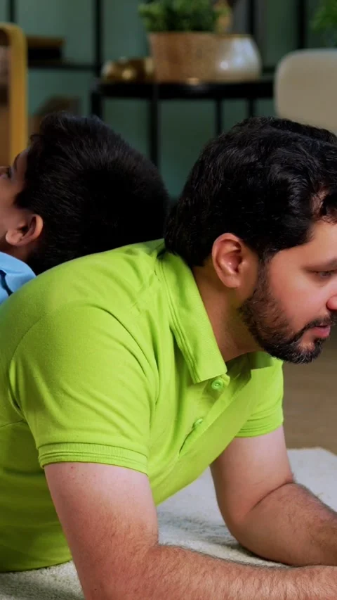 Indian asian man using laptop son playing mobile game together on carpet Stock Footage 342758117