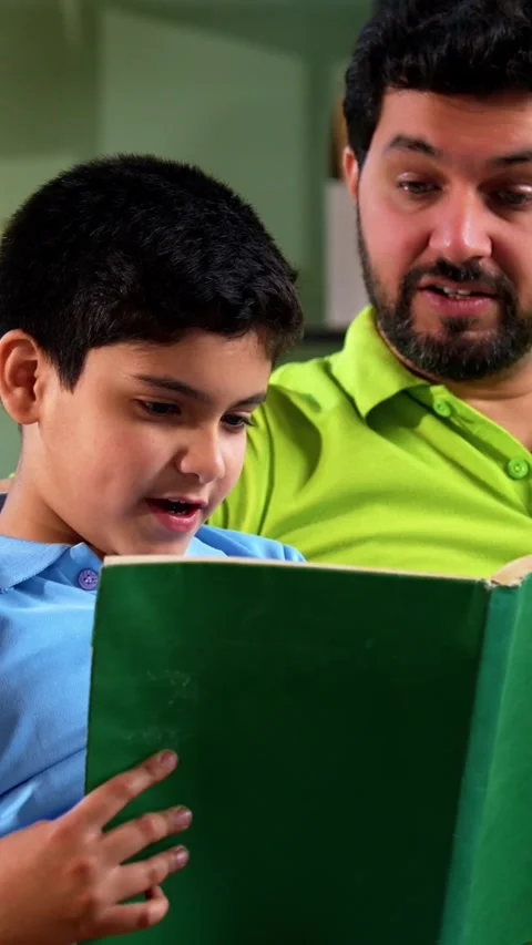 Indian asian son reading book with father as dad supports study time Stock Footage 342758013